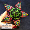 The Tulips beaded star ornament held in hand