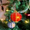 round beaded lantern ornaments glowing on a Christmas tree