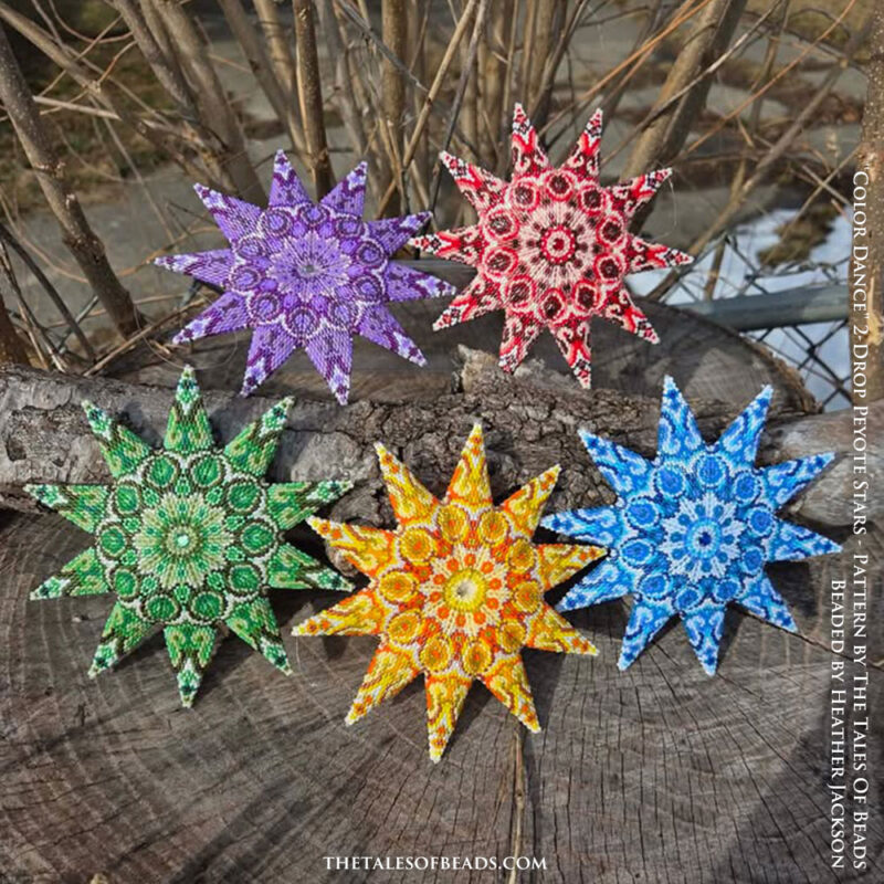 A set of five colorful 2-drop peyote stars photographed on a decorative wood stump
