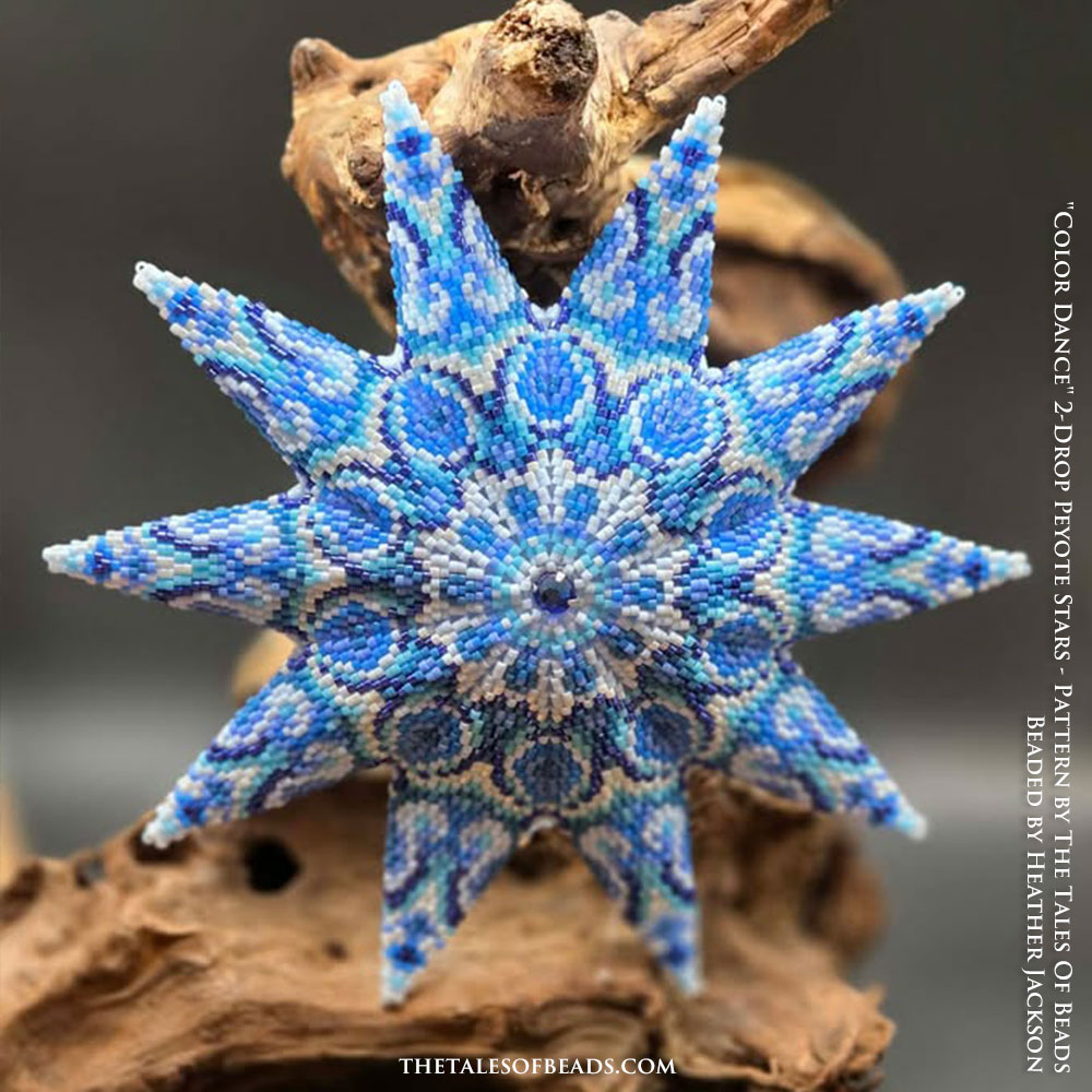 Handcrafted 2-draft peyote star in shades of blue displayed against a natural branch
