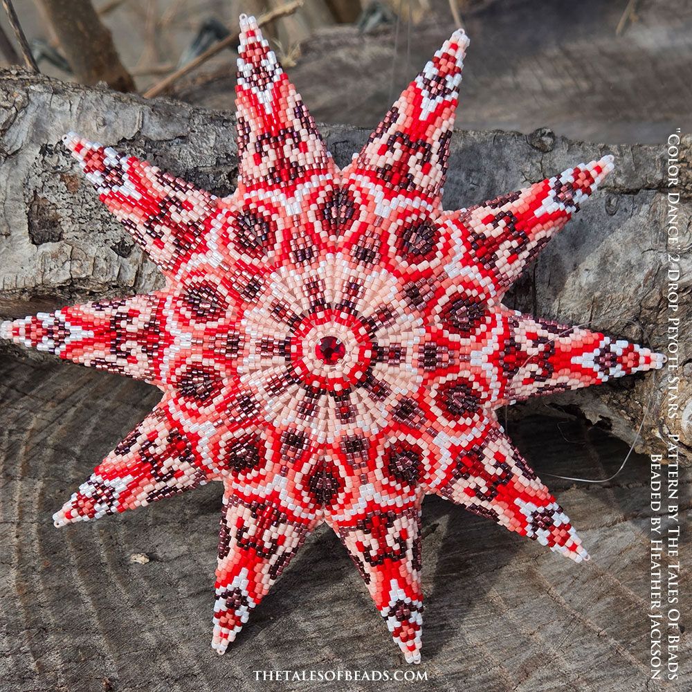 Ten point peyote star in shades of red displayed on rustic wooden stump