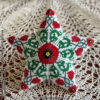 Peyote star with entwined poppies design showcased on a lace tablecloth